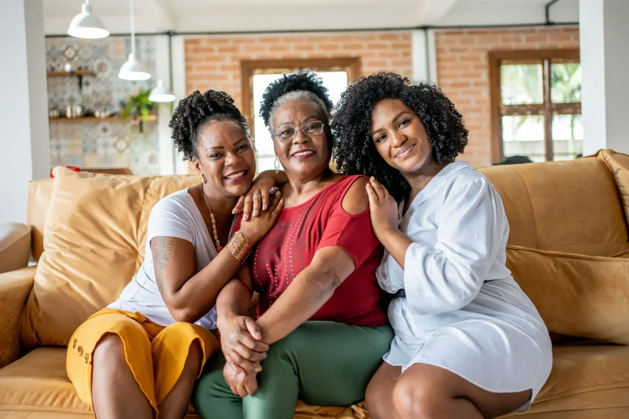 Three women sitting together on a couch.